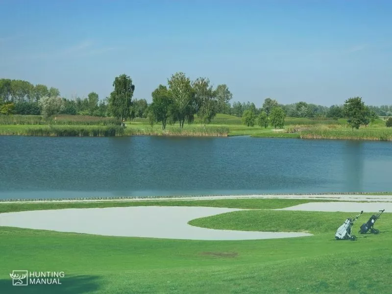 a golf field with water pond in it